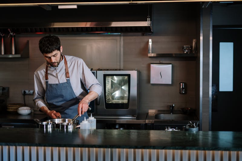 Head chef preparing artisan pizza in the kitchen